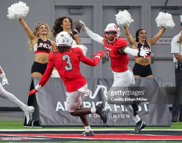 Defensive backs Johnathan Baldwin and Jerrae Williams of the UNLV Rebels celebrate after Williams recovered a fumble and scored a touchdown against...