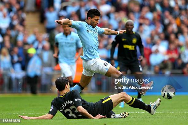 Sergio Aguero of Manchester City evades the challenge from Paul Scharner of Wigan Athletic during the FA Cup with Budweiser Final between Manchester...