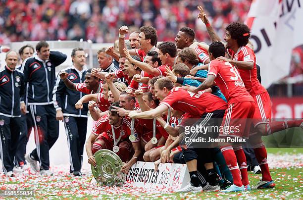 The FC Bayern Muenchen players and staff celebrate with the Bundesliga trophy following their match against Augsburg at the Allianz Arena on May 11,...