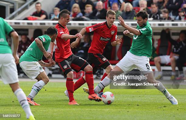 Mario Eggimann and Sergio Da Silva Pinto of Hannover tackle Lars Bender and Arkadiusz Milik of Leverkusen during the Bundesliga match between Bayer...