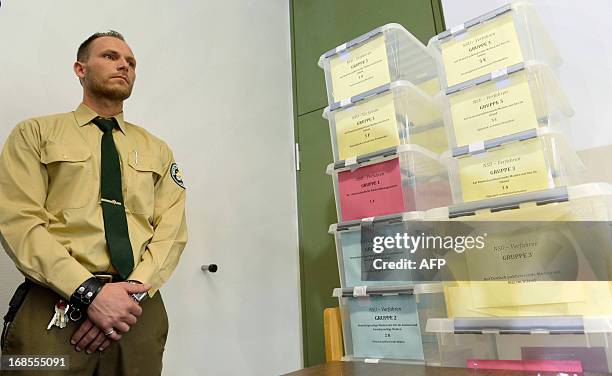 Security officer of the Higher Regional Court Munich stands by boxes filled with media accreditation demands for the NSU to be assigned by lottery on...