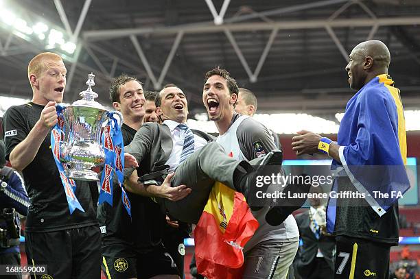 Goalscorer Ben Watson of Wigan Athletic with the trophy as goalkeeper Joel Robles and team mates carry manager Roberto Martinez as they celebrate...