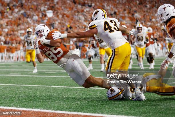 Gunnar Helm of the Texas Longhorns is tackled short of the goal line by Wyett Ekeler of the Wyoming Cowboys in the second quarter at Darrell K...