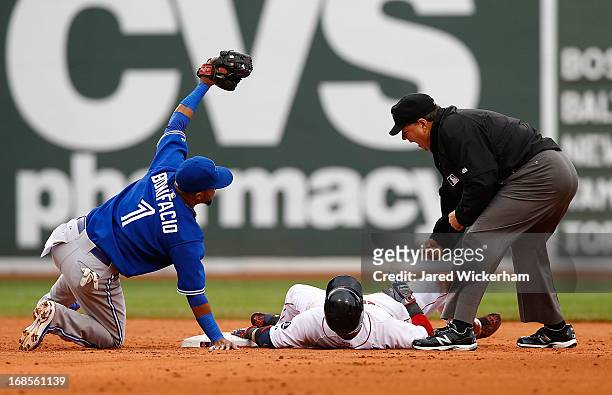 Emilio Bonifacio of the Toronto Blue Jays tags out Dustin Pedroia of the Boston Red Sox at second base following an attempted double during the game...