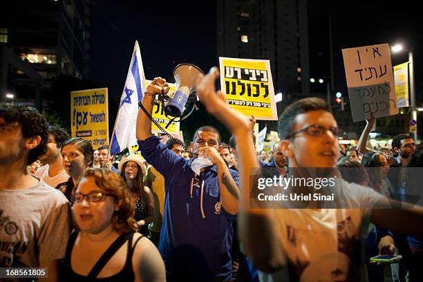 Demonstrators march through the streets to protest against Israeli Finance Minister Yair Lapid's budget cuts on May 11, 2013 in Tel Aviv, Israel....