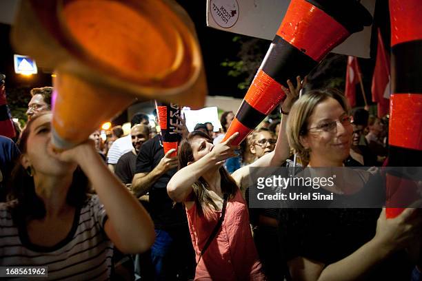 Demonstrators march through the streets to protest against Israeli Finance Minister Yair Lapid's budget cuts on May 11, 2013 in Tel Aviv, Israel....