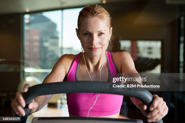 woman listening music exercising in gym - トレッドミル　女性 ストックフォトと画像