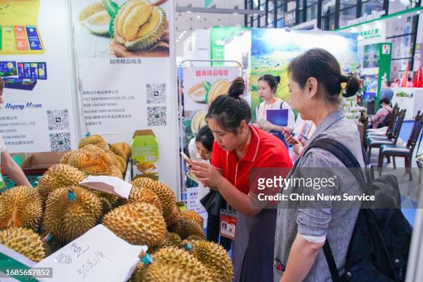 Staff member takes photos at Vietnamese durian booth during the 20th China-ASEAN Expo at Nanning International Convention and Exhibition Center on...