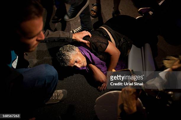 An Israeli woman is wounded on the ground after scuffling with the polce as demonstrators march through the streets to protest against Israeli...