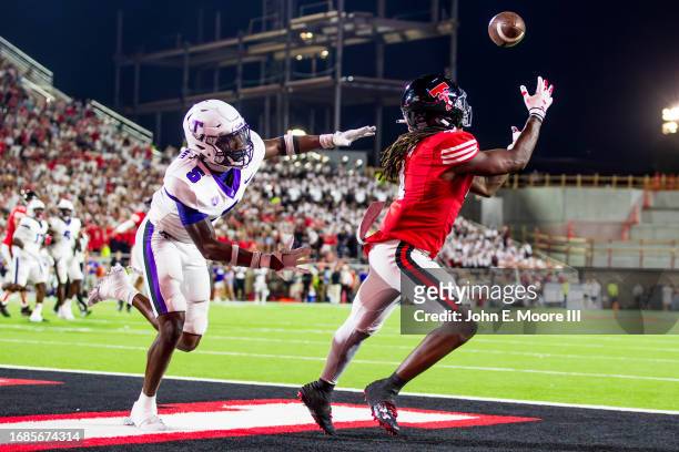 Jordan Brown of the Texas Tech Red Raiders catches a pass for a touchdown against Dabari Hawkins of the Tarleton State Texans during the second half...