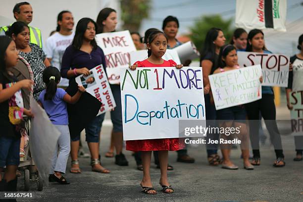 Alisa Ramirez holds a sign reading "Not 1 More Deportation" as she and others participate in a rally calling on President Barack Obama to immediately...