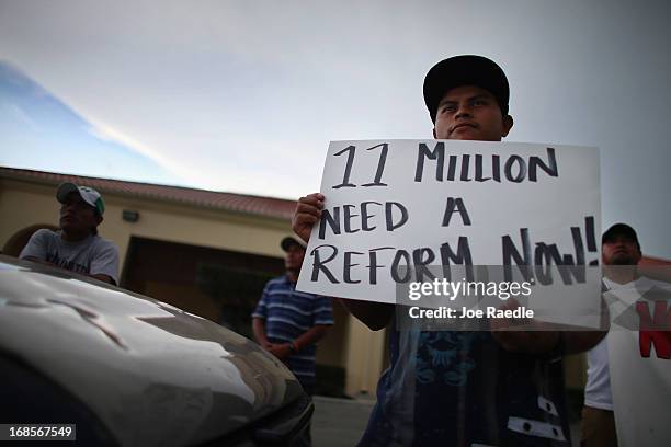 Raul Pop holds a sign reading "11 million need a reform now!" as he and others participate in a rally calling on President Barack Obama to...