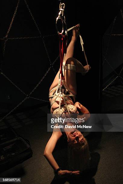 Participant called Dalbin makes dance-like moves as she is suspended in ropes at a dungeon party during the domination convention, DomConLA, in the...