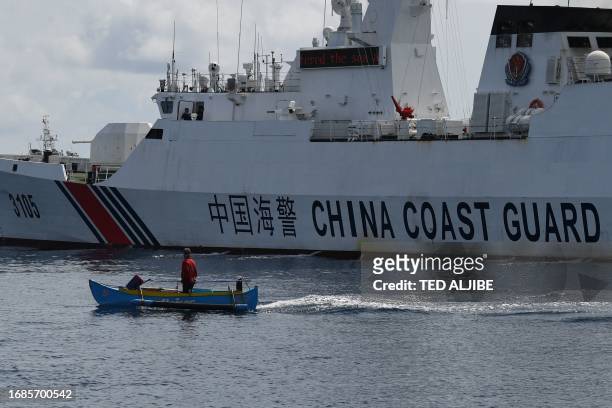 This photo taken on September 22, 2023 shows a wooden boat, with Philippine fisherman Arnel Satam on board, drawfed by a Chinese coast guard vessel...