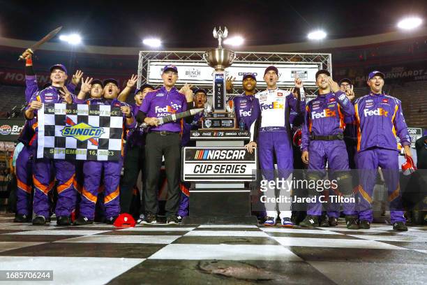 Denny Hamlin, driver of the FedEx Freight Direct Toyota, and crew celebrate in victory lane after winning the NASCAR Cup Series Bass Pro Shops Night...