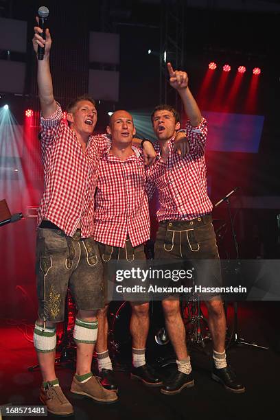 Bastian Schweinsteiger of Bayern Muenchen performes with his team mates Arjen Robben and Thomas Mueller live on stage during the Official Champion...