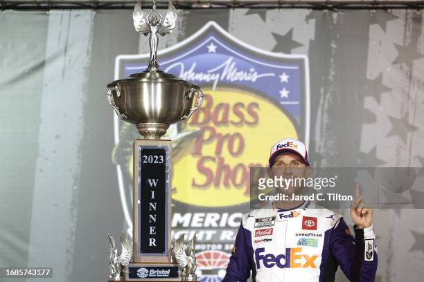 Denny Hamlin, driver of the FedEx Freight Direct Toyota, celebrates in victory lane after winning the NASCAR Cup Series Bass Pro Shops Night Race at...