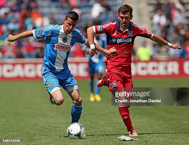 Sebastien Le Toux of the Philadelphia Union holds off Gonzalo Segares of Chicago Fire during an MLS match at Toyota Park on May 11, 2013 in...