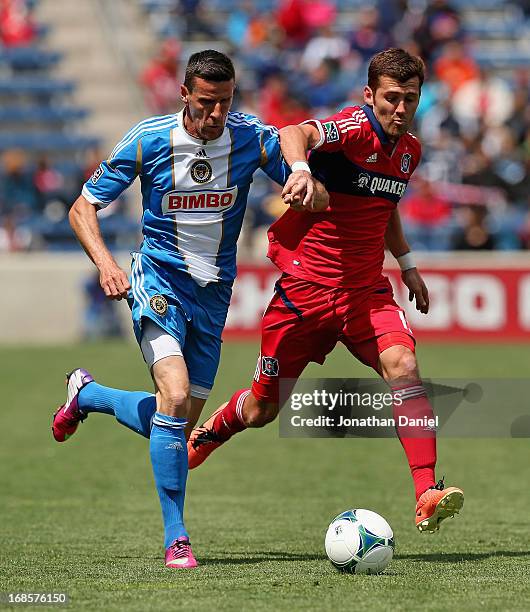 Sebastien Le Toux of the Philadelphia Union holds off Gonzalo Segares of Chicago Fire during an MLS match at Toyota Park on May 11, 2013 in...