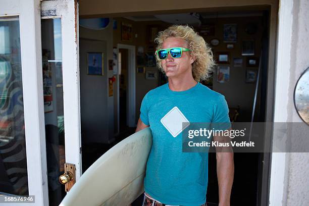 surfer standing in doorway with sunglasses - wavy hair man stock pictures, royalty-free photos & images