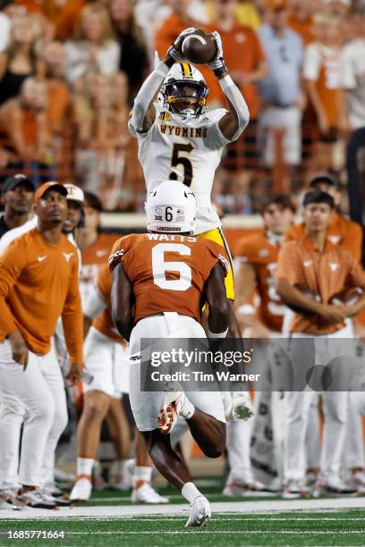 Ayir Asante of the Wyoming Cowboys catches a pass while defended by Ryan Watts of the Texas Longhorns in the third quarter at Darrell K Royal-Texas...