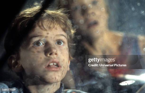 Joseph Mazzello and Ariana Richards look out a window in a scene from the film 'Jurassic Park', 1993.
