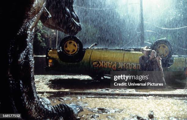 T-rex approaches the flipped truck in a scene from the film 'Jurassic Park', 1993.