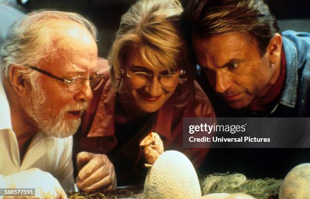 Richard Attenborough, Laura Dern and Sam Neill watch a hatching in a scene from the film 'Jurassic Park', 1993.