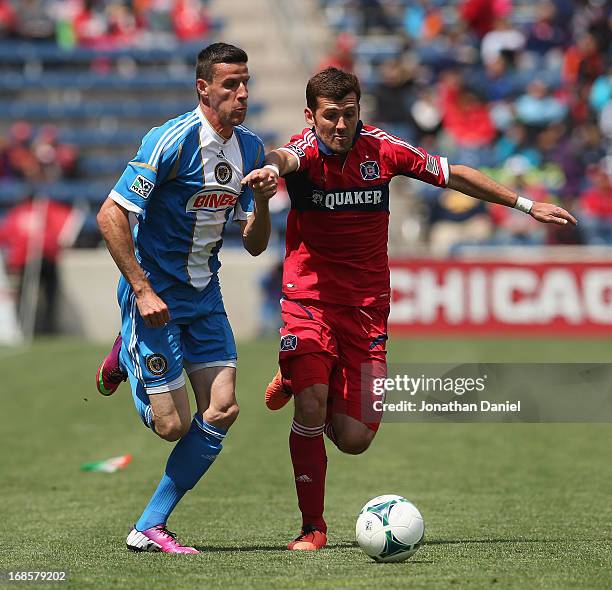 Sebastien Le Toux of the Philadelphia Union holds off Gonzalo Segares of Chicago Fire during an MLS match at Toyota Park on May 11, 2013 in...