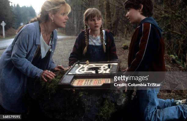 Bonnie Hunt, Kirsten Dunst and Bradley Pierce look at the game in a scene from the film 'Jumanji', 1995.