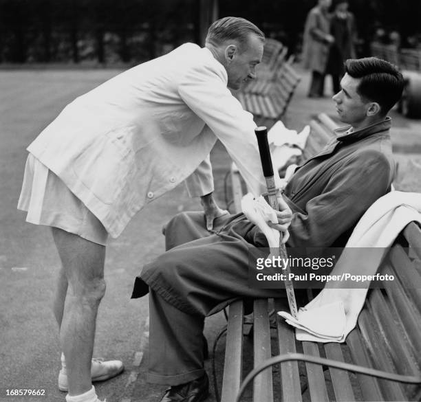 Australian Davis Cup team manager Harry Hopman has a word with one of his players during a break in practice at Wimbledon, London, 16th May 1950.