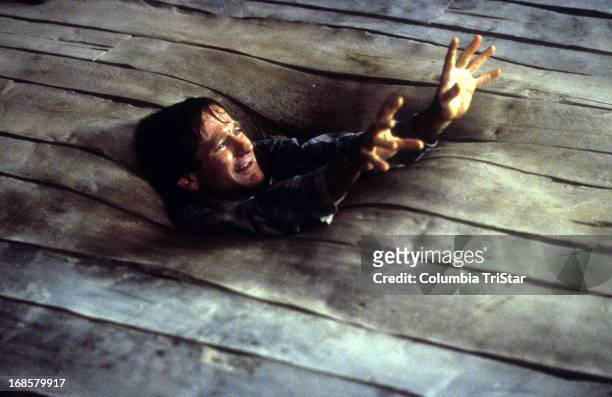 Robin Williams sinks into the floor in a scene from the film 'Jumanji', 1995.