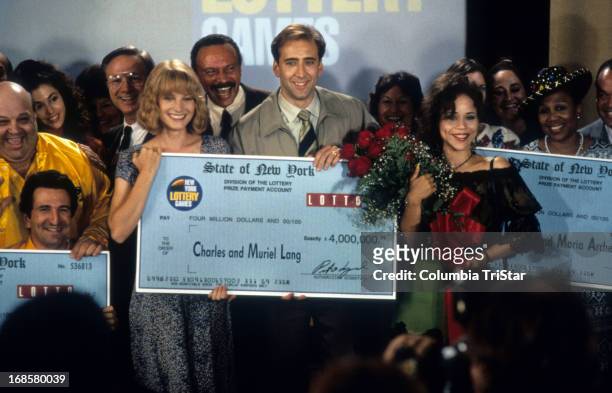 Bridget Fonda, Nicolas Cage and Rosie Perez stand in front of a big check in a scene from the film 'It Could Happen To You', 1996.