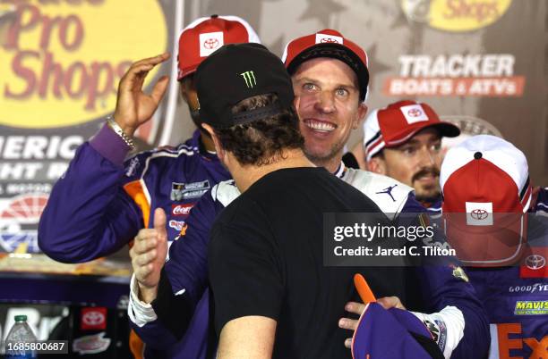 Denny Hamlin, driver of the FedEx Freight Direct Toyota, is congratulated by retired NASCAR Cup Series driver, Kurt Busch in victory lane after...