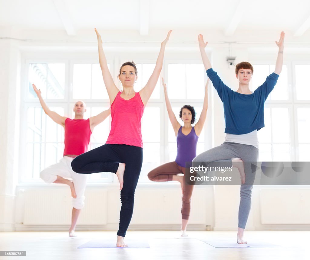 Group of people doing the yoga tree position