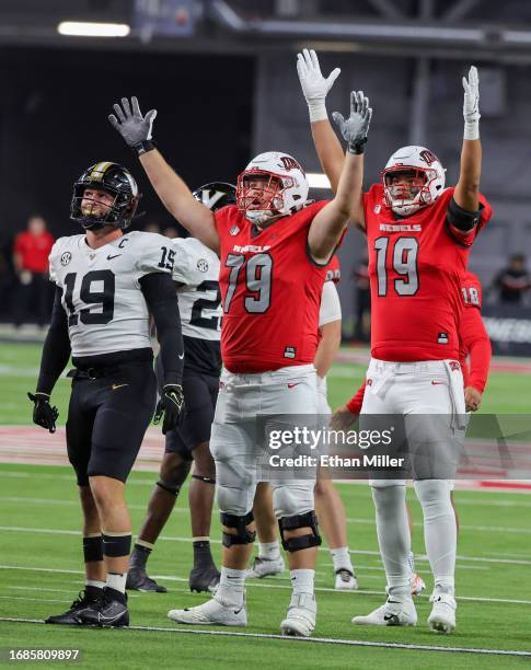 Linebacker Kane Patterson of the Vanderbilt Commodores and offensive lineman Austin Boyd and tight end Kaleo Ballungay of the UNLV Rebels react as a...