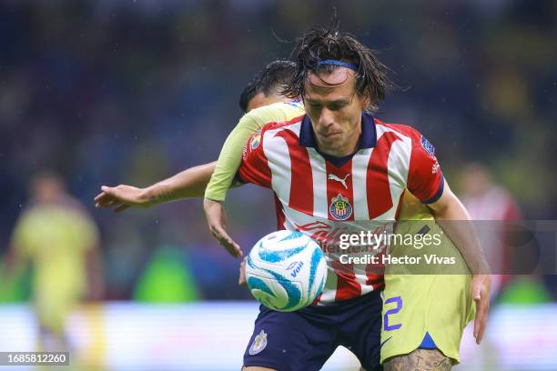 Leonardo Suarez of America battles for possession with Fernando Gonzalez of Chivas during the 8th round match between America and Chivas as part of...