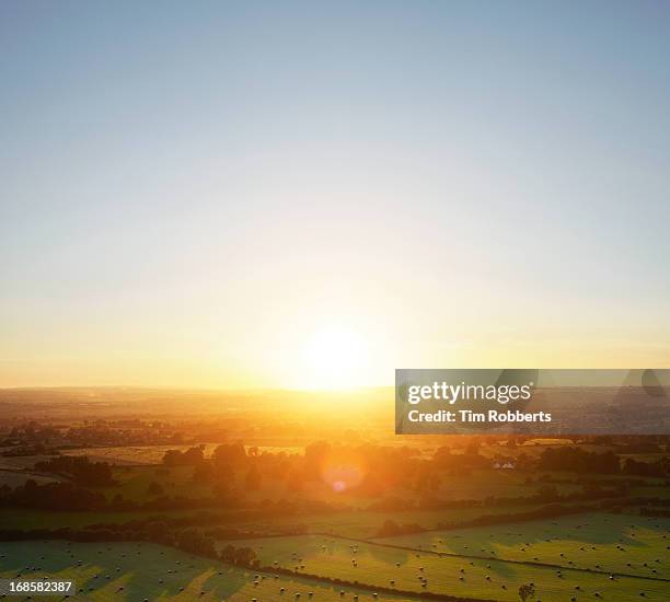 sunset over green fields landscape. - morning sky stock-fotos und bilder