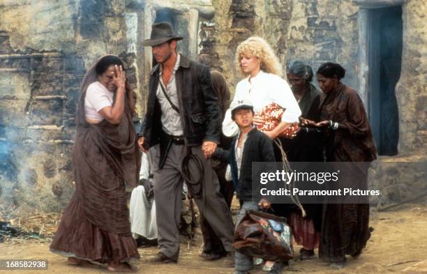 Harrison Ford, Jonathan Ke Quan and Kate Capshaw are lead through a temple in a scene from the film 'Indiana Jones And The Temple Of Doom', 1984.