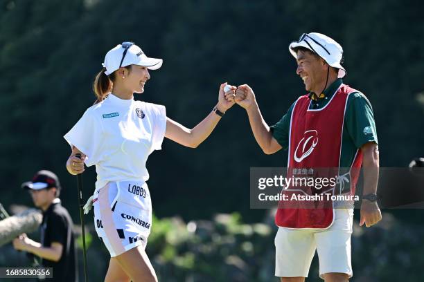 Karen Tsuruoka of Japan fist bumps with her caddie after holing out with the birdie on the 18th green during the final round of 54th SUMITOMO LIFE...