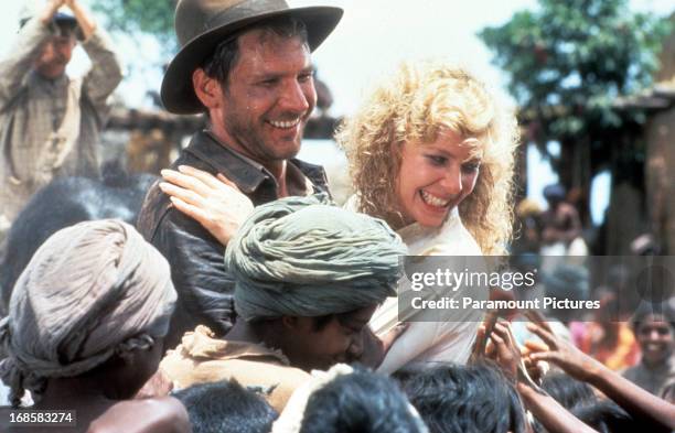 Harrison Ford and Kate Capshaw are greeted by children in a scene from the film 'Indiana Jones And The Temple Of Doom', 1984.