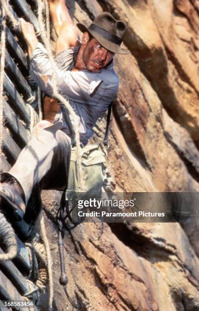 Harrison Ford descends down a cliff in a scene from the film 'Indiana Jones And The Temple Of Doom', 1984.