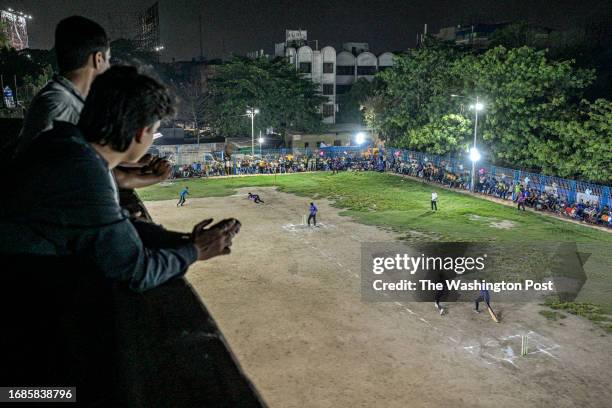 Residents watch night cricket tournament in progress where Javed Rehman got lights installed for youngsters to play in the local community ground in...
