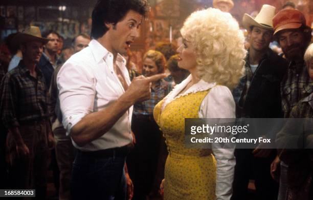Sylvester Stallone points to Dolly Parton in a scene from the film 'Rhinestone', 1984.