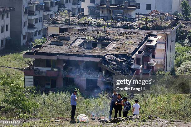 Relatives of earthquake victims burn offerings to mourn their relatives at the ruins of earthquake-hit Beichuan county during the five year...