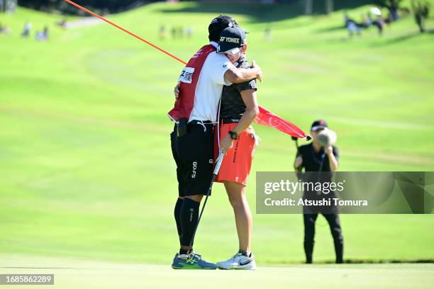 Akie Iwai of Japan celebrates with her caddie after winning the tournament on the 18th green during the final round of 54th SUMITOMO LIFE Vitality...