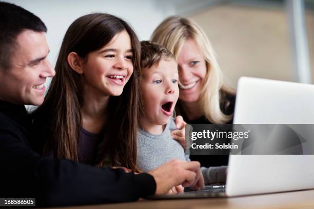 family using laptop together - boy computer smile fotografías e imágenes de stock