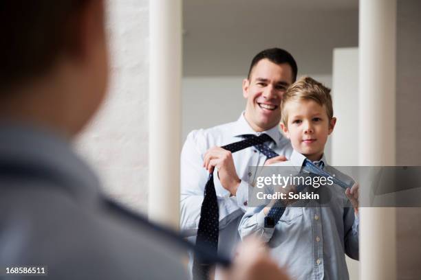 father teaching son to tie a tie - morgens anziehen stock-fotos und bilder