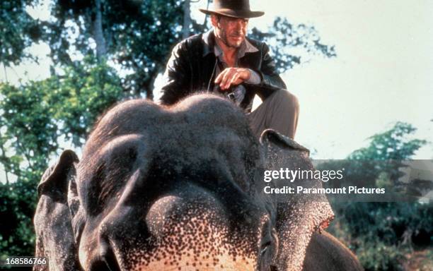 Harrison Ford rides an elephant in a scene from the film 'Indiana Jones And The Temple Of Doom', 1984.