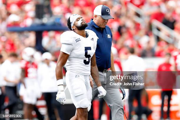 Smith of the Georgia Southern Eagles walks off the field with head coach Clay Helton during the game against the Wisconsin Badgers at Camp Randall...